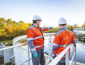 Two workers wearing helmets, masks and gloves in a wastewater treatment plant. © Médiathèque VEOLIA - Jérôme Sevrette / ANDIA